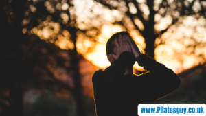 Image of man with hands over face, looking toward sky in early morning
