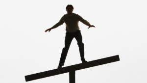 Person balancing on unstable seesaw